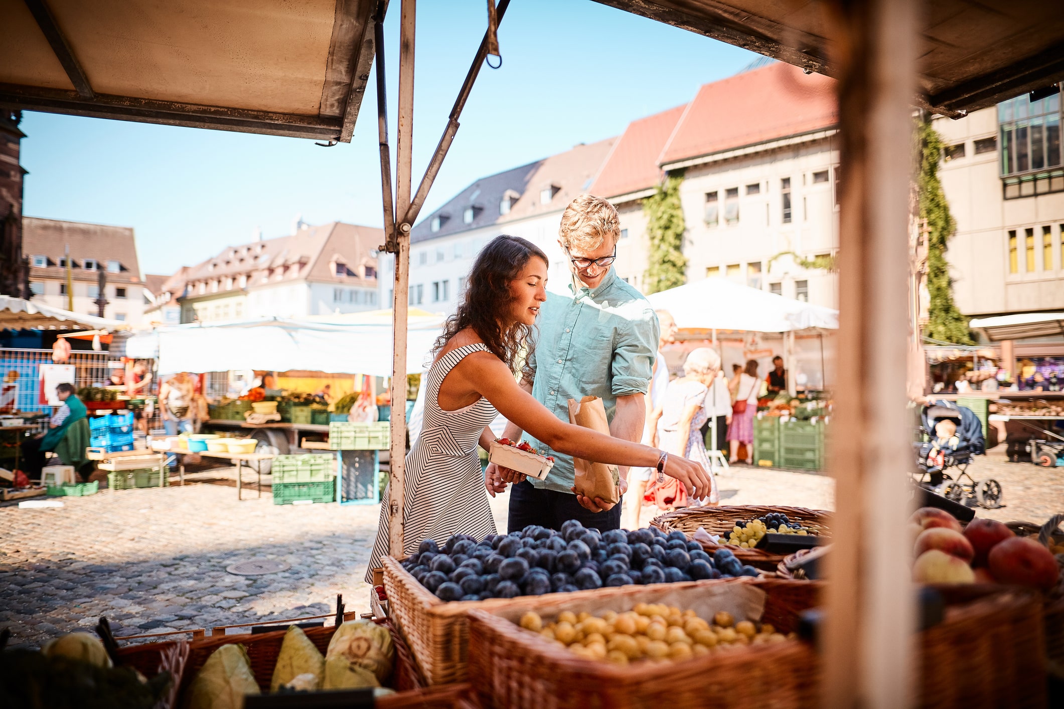Two people shopping at outdoor fruit market in Freiburg, Germany