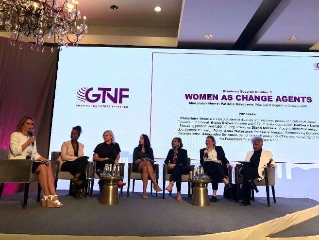 Group image of women sitting in front of a presentation that reads 'Women as Change Agents'